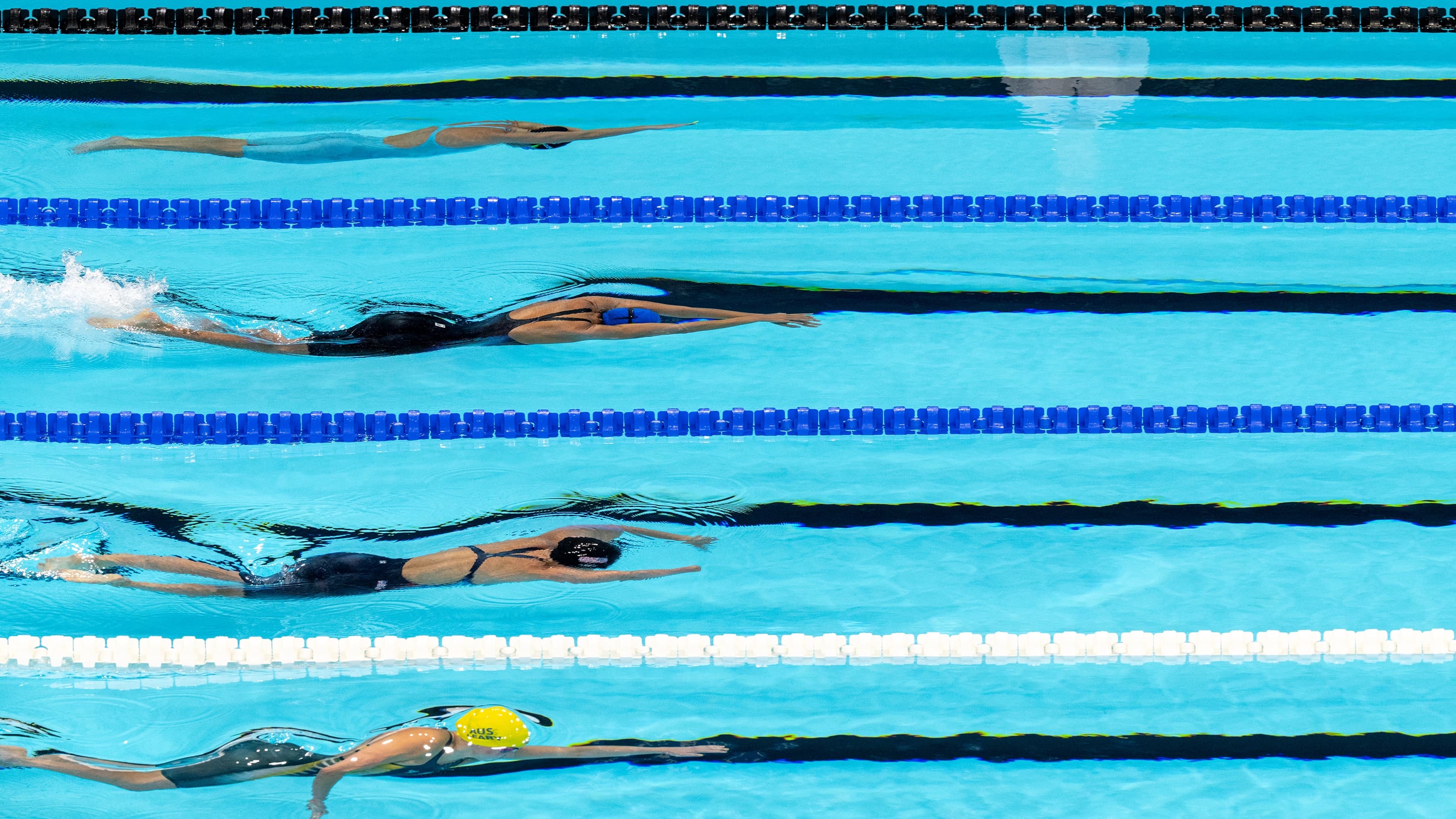Swimmers about to break through the water during race