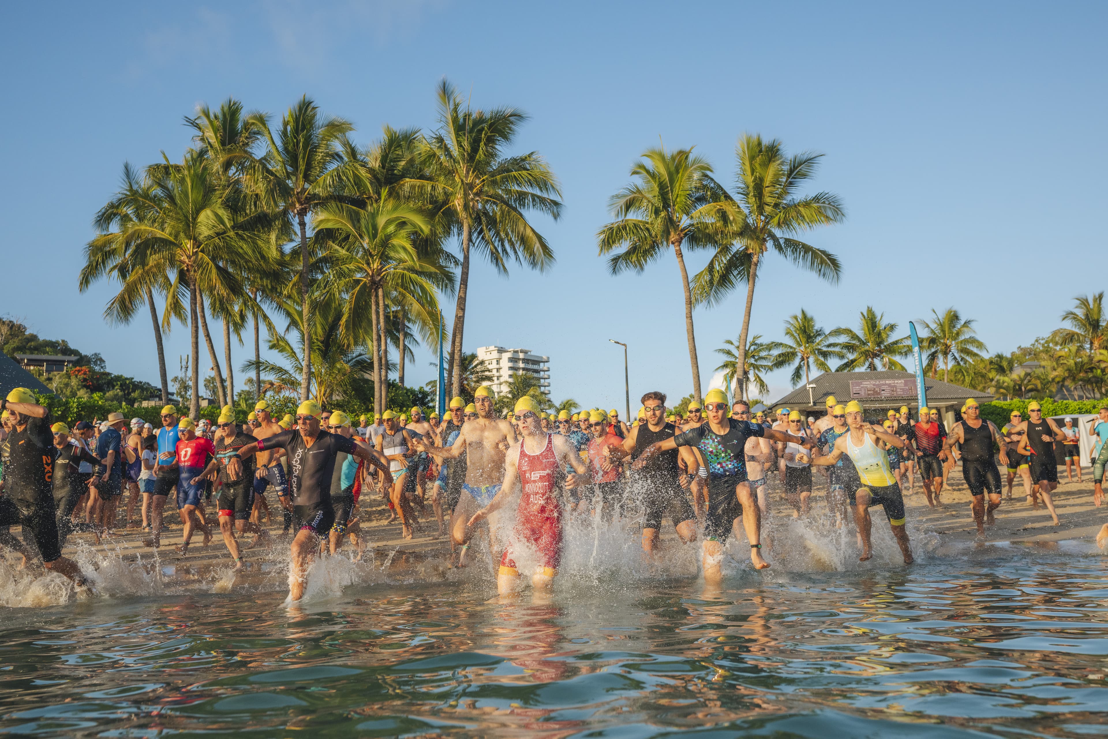 Swimmers running into the water at Hamilton Island Triathlon