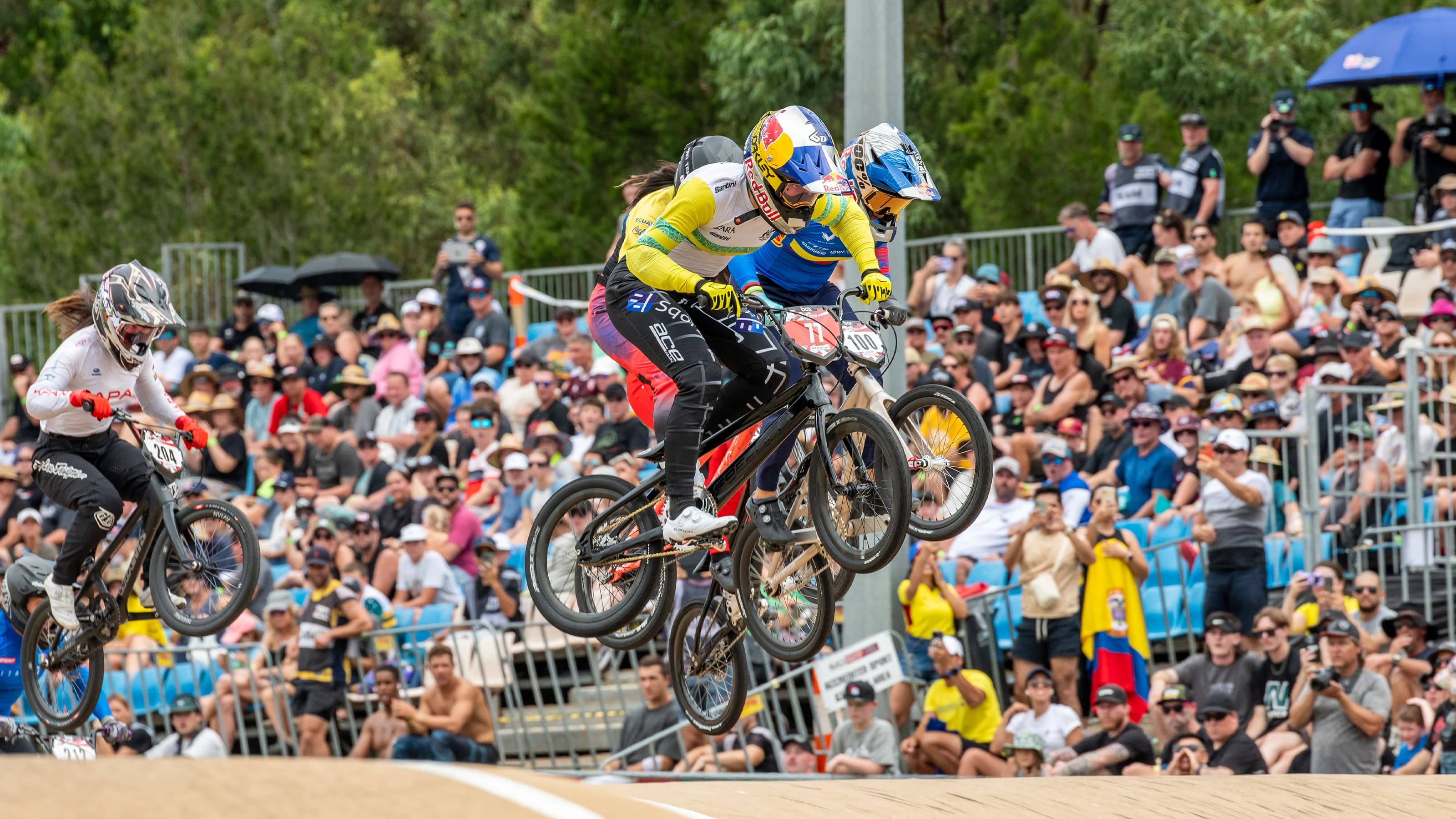 BMX riders mid jump during a race