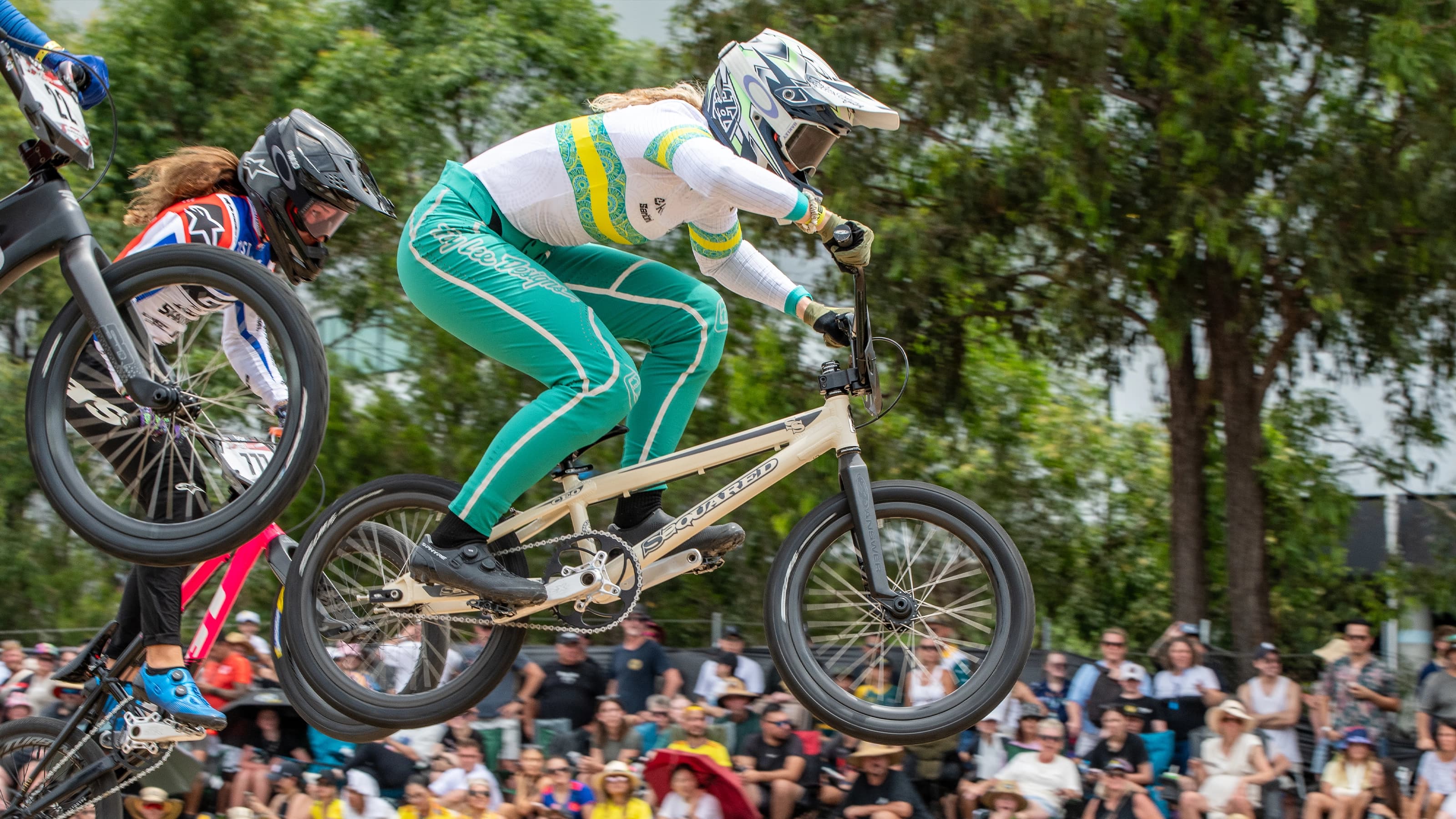 BMX riders mid jump during a race