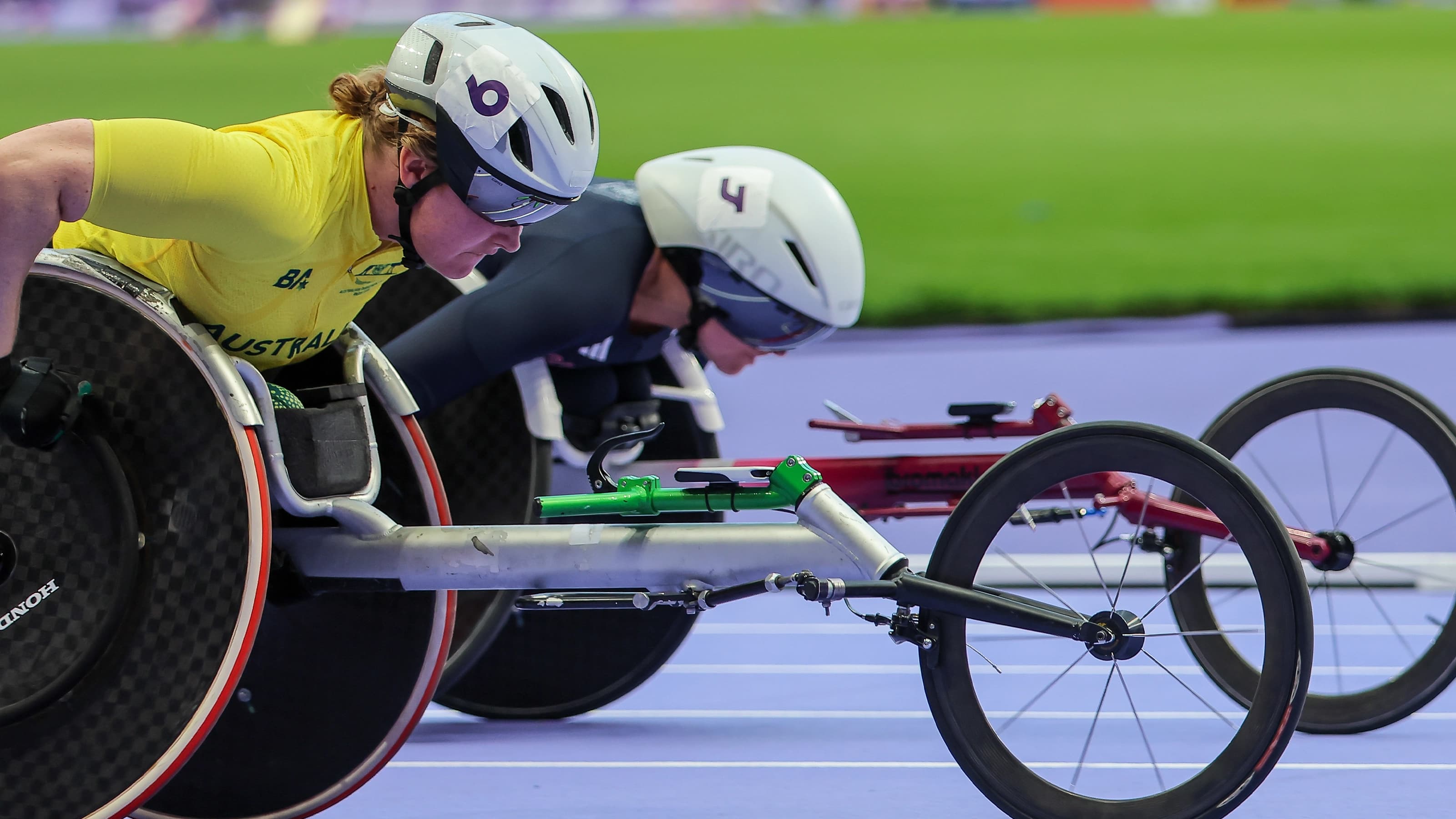 Para athletes in racing wheelchairs on athletics track