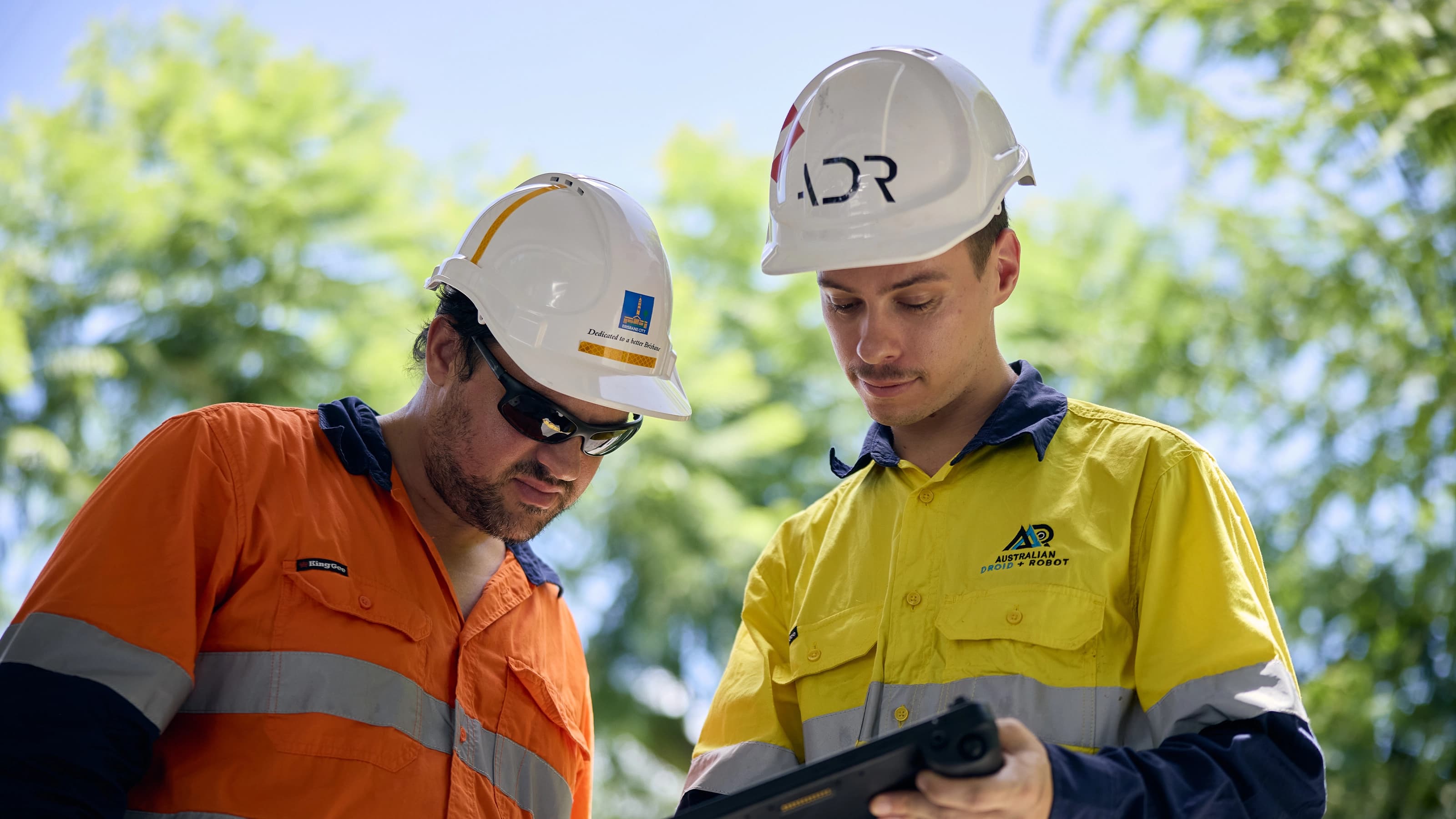 Two construction workers looking at a tablet