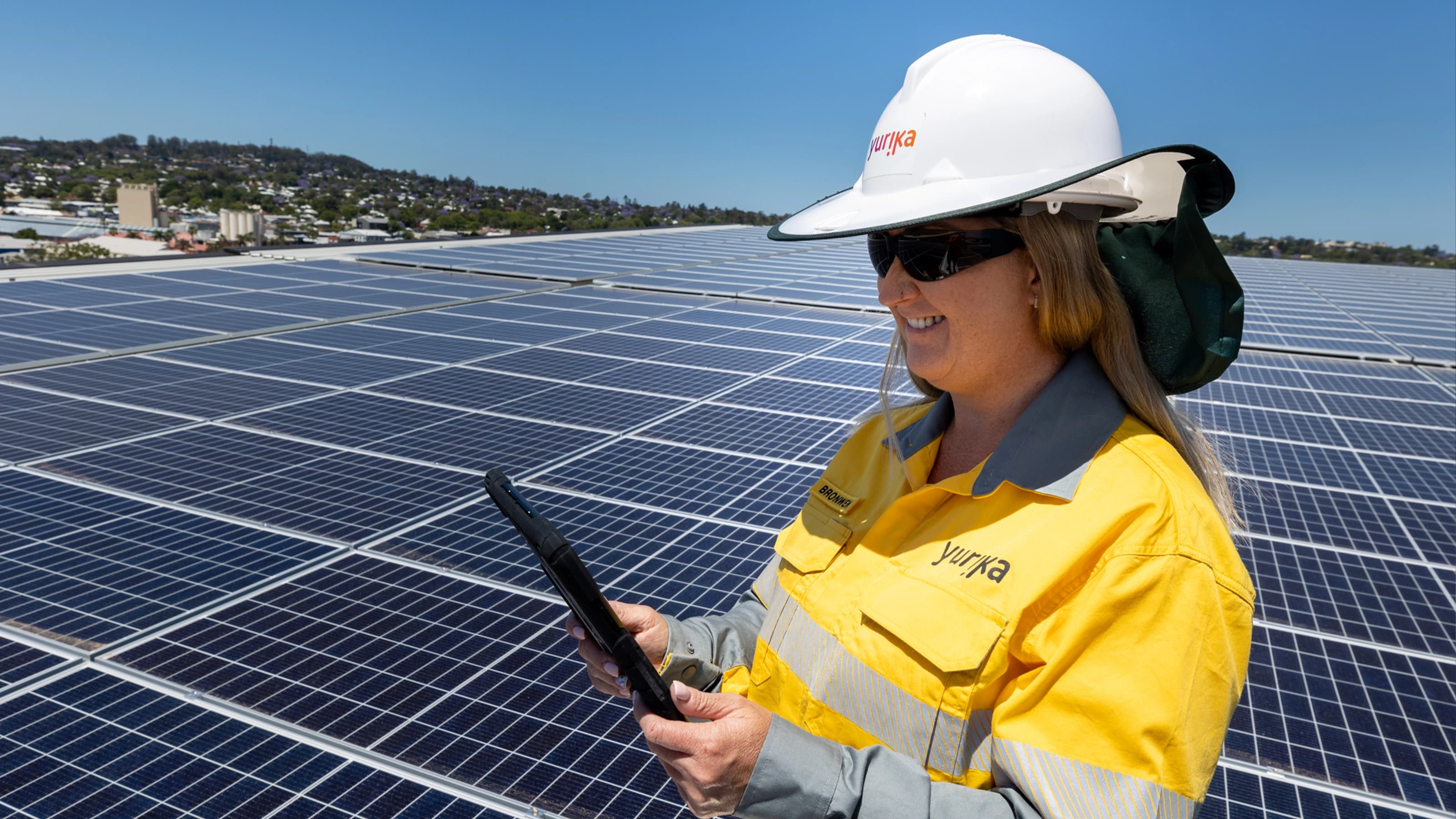 Worker looking at tablet at solar panel farm
